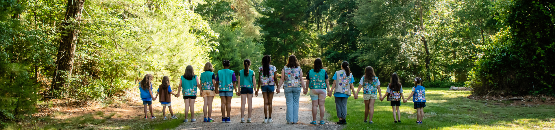  Group of Girl Scouts smiling at each other outdoors 